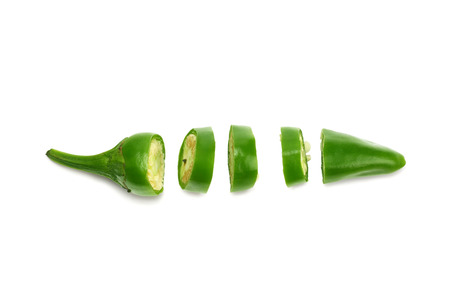 sliced green hot chili peppers isolated on white background top viewの写真素材