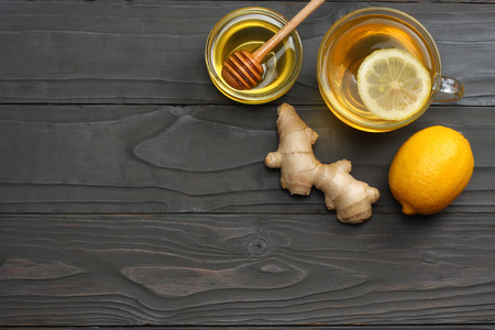 healthy background. honey, honeycomb, lemon, tea, ginger on dark wooden table. Top view with copy spaceの写真素材
