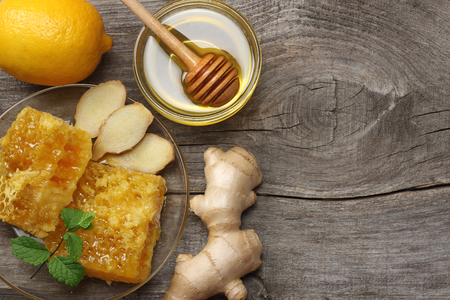 healthy background. honey, honeycomb, lemon, ginger on old wooden table. Top view with copy spaceの写真素材
