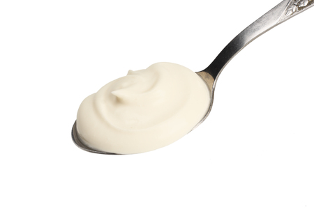 sour cream in spoon isolated on white backgroundの写真素材