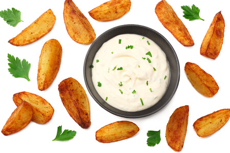 Fried potato wedges with garlic sauce in black bowl isolated on white background. top view.の写真素材