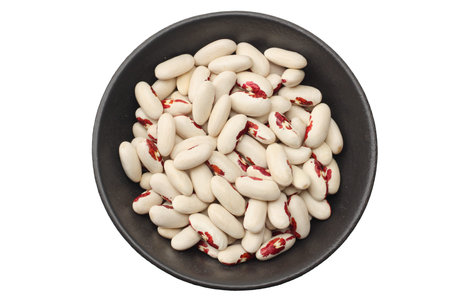 white kidney beans in black bowl isolated on white background. top view