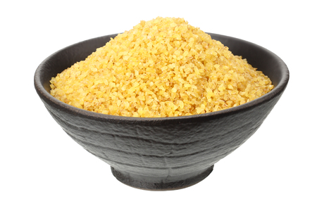 dry bulgur wheat in bowl isolated on white backgroundの写真素材