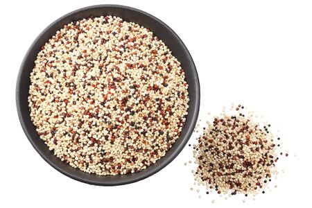 quinoa in a black bowl isolated on white background. quinoa seed. top viewの写真素材