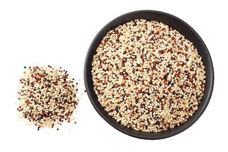 quinoa in a black bowl isolated on white background. quinoa seed. top viewの写真素材