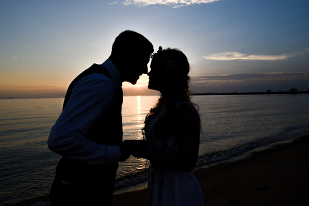 Silhouette couple on the beach with sunsetの写真素材