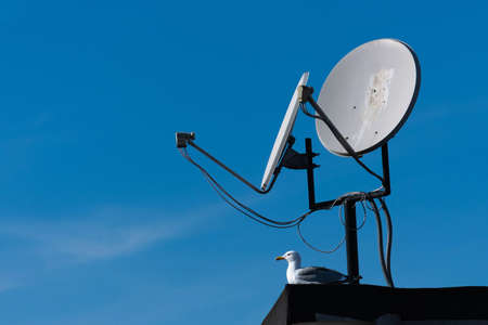 satellite dishes on the roof, blue skyの写真素材