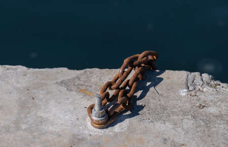 rusty chain attached to the screw, on concrete,の写真素材