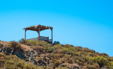 abandoned old wooden pergola on the hill, blue skyの写真素材