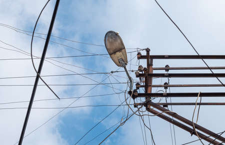 cable clutter on electric pole, street lampの写真素材