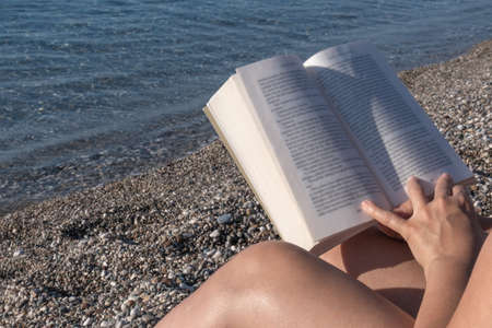 woman reading a book on the beachの写真素材