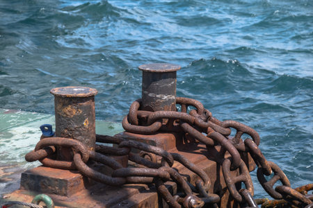 bollards and rusty chains by seasideの写真素材
