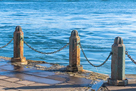 old metal casting barriers and chains by the seaの写真素材