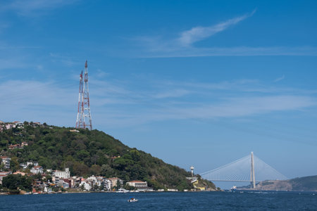 High voltage transmission tower in Bosphorus and between residential areas. 
Yavuz Sultan Selim Suspension Bridge in the background. istanbul, turkey.の写真素材