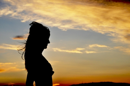 Sunset picture with silhouette womanの写真素材