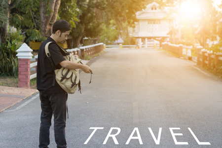 Young man tourist look in backpack on road.travel backconceptの写真素材