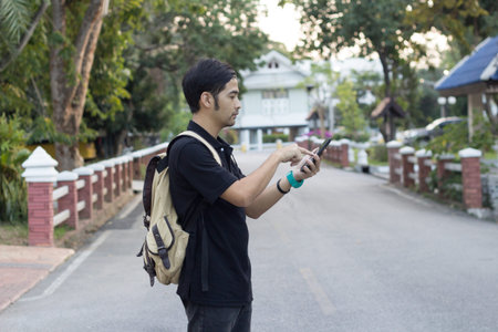 Man with backpack using smart phone on road.travel technology concept