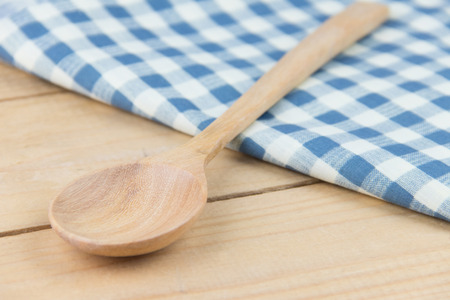 Closeup wooden spoon on napkin blue and white plaid on wooden tableの写真素材