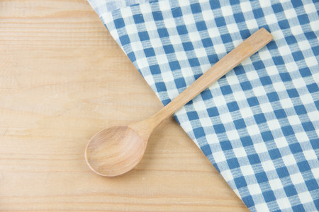Wooden spoon on napkin blue and white plaid on wooden tableの写真素材