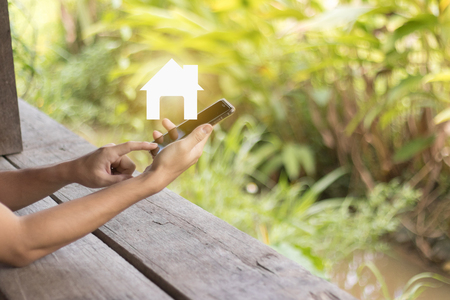 Hand hold mobile phone with home icon. business concept ideaの写真素材