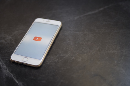 Chiang mai, Thailand - february 6 2018 : Smartphone brand apple iphone 6 white color open application youtube on screen on wooden tableのeditorial素材
