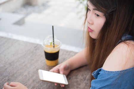 Close-up Woman hold smartphone outside coffee cafeの写真素材