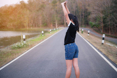 Girl raised an arm workout beside leak at the park