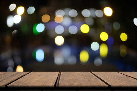Ole empty wooden table of brown on front blurred night colorful backgroundの写真素材