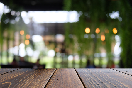 Empty wooden table on front blurred coffee shop abstract background, used for presentation or templateの写真素材