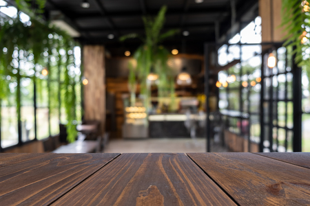 Empty wooden table of brown on front in blurred coffee shop background, image for presentation productの写真素材