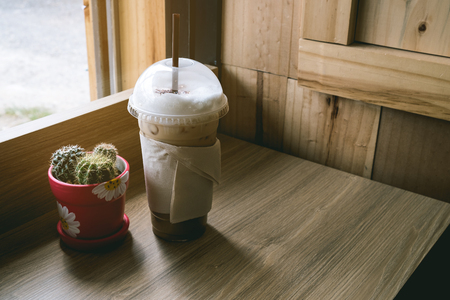 Ice cappuccino coffee on wooden floor, beside windowの写真素材