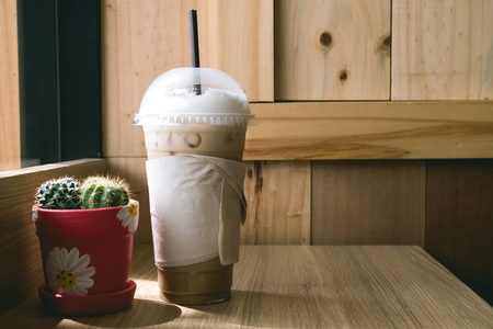 Iced fresh coffee and cactus on desk, copy space, backgroundの写真素材