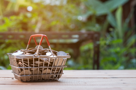 Close up Lot of coin in basket on wooden table nature background, saving money concept, copy spaceの写真素材