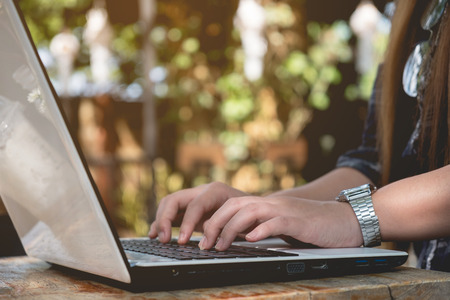 Woman typing on laptop keyboard with sunshine, close up, business freelance conceptの写真素材
