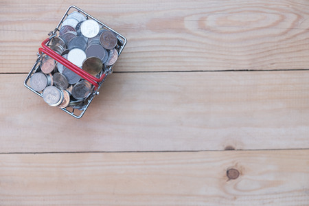 Copy space, Lot of coin in basket on wooden table, top view background, saving money conceptの写真素材