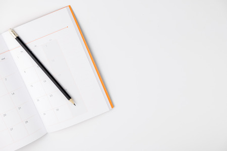 Empty Calendar book and pencil on white isolated background, top view, copy spaceの写真素材
