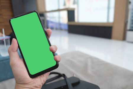 Cropped hand of man using mobile phone, mock up on screenの写真素材