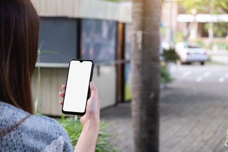 Woman using mobile phone, outdoor, mock up on screenの写真素材