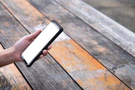 Woman using mobile phone on wooden table, copy space for use advertising and presentation, template website, white isolated on screenの写真素材