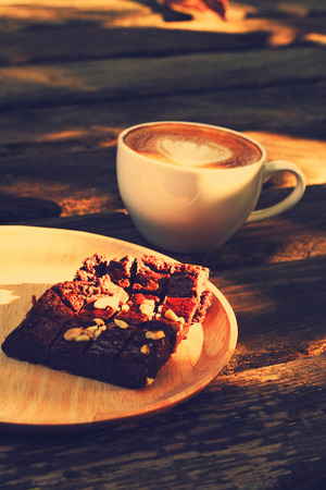Cup of latte or cappuccino and brownie in retro filter effect の写真素材