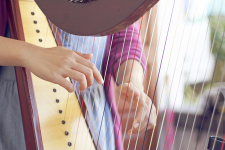 Closeup of a woman playing the harp with soft retro filter effect lighting or instagram filterの写真素材