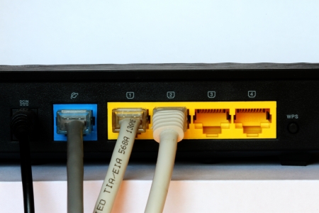 photo of the black small router with network cablesの写真素材
