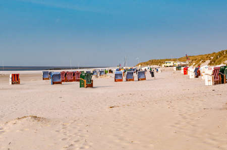 Colorful beach chairs on the beach. The sea is visible on the horizon. Blue, cloudless sky.の写真素材