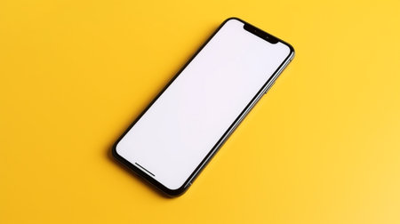 Smartphone with blank white screen on yellow background. Top view.の素材