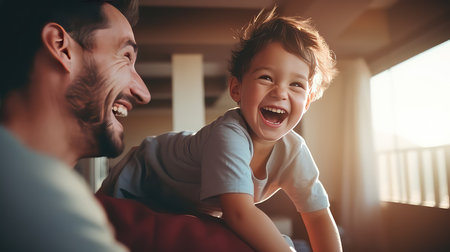 Happy father and son playing together at home. They are laughing and looking at each other. Focus on boyの素材