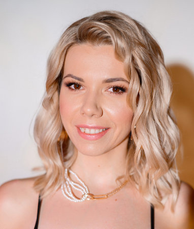 Close-up portrait of a beautiful girl on a background of colored yellow light in a black dress