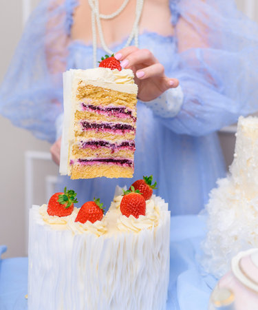 Beautiful brunette woman cuts a beautiful big white cake