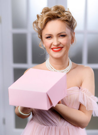 Beautiful blonde woman holding a pink box