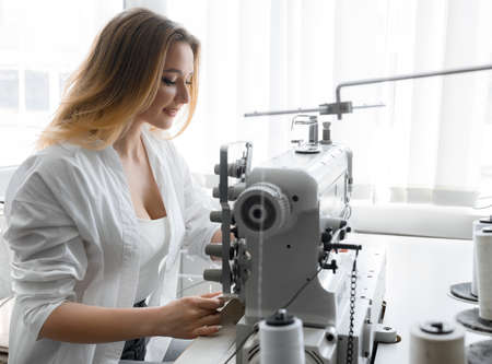 Young beautiful light hair seamstress. Small business conceptの写真素材