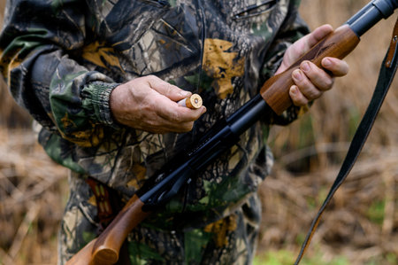 Hunter charges a cartridge into the chamber of a rifle close up